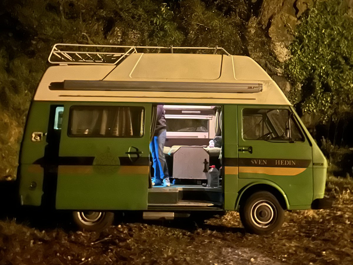 VW LT28 Westfalia at night with the sliding door open and the interior lit
